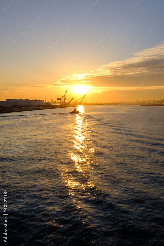夕陽とボートの波。オレンジ色に染まる空。神戸六甲アイランドから三宮方面を臨む