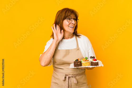 Middle age caucasian cook woman trying to listening a gossip.