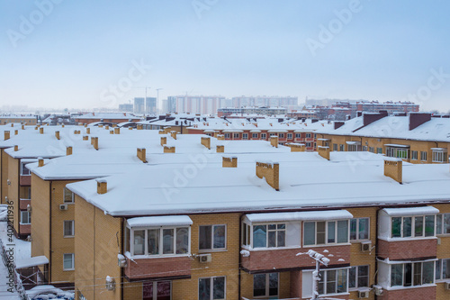 Snow-covered roofs of houses in winter. City panorama  top view