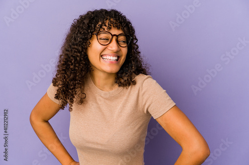Young african american afro woman isolated laughs and closes eyes, feels relaxed and happy. © Asier
