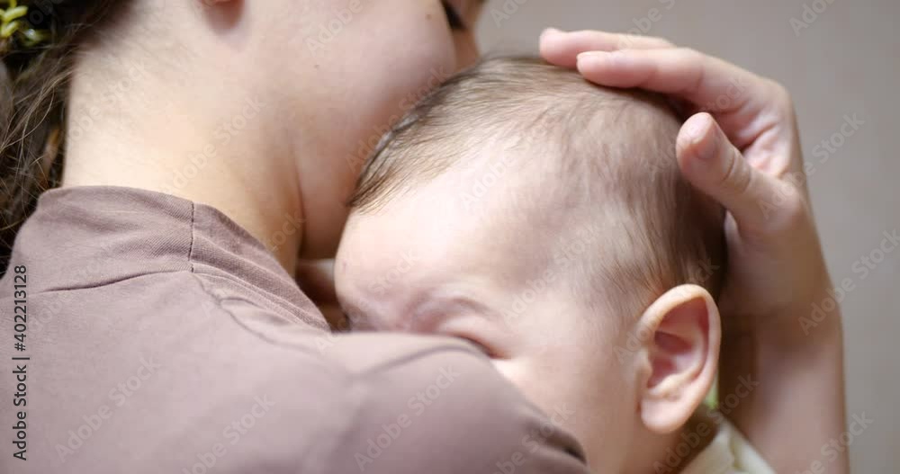 baby in mom's arms looking at the camera. Motherhood concept baby in mom's arms looking at the camera. Motherhood concept