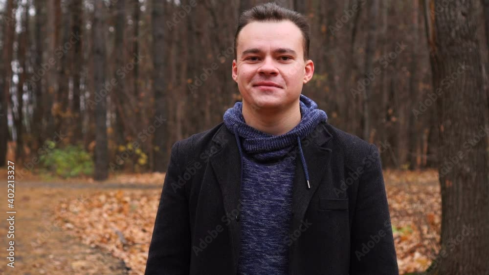 Man looking at camera and smiling in autumn park Man looking at camera and smiling in autumn park