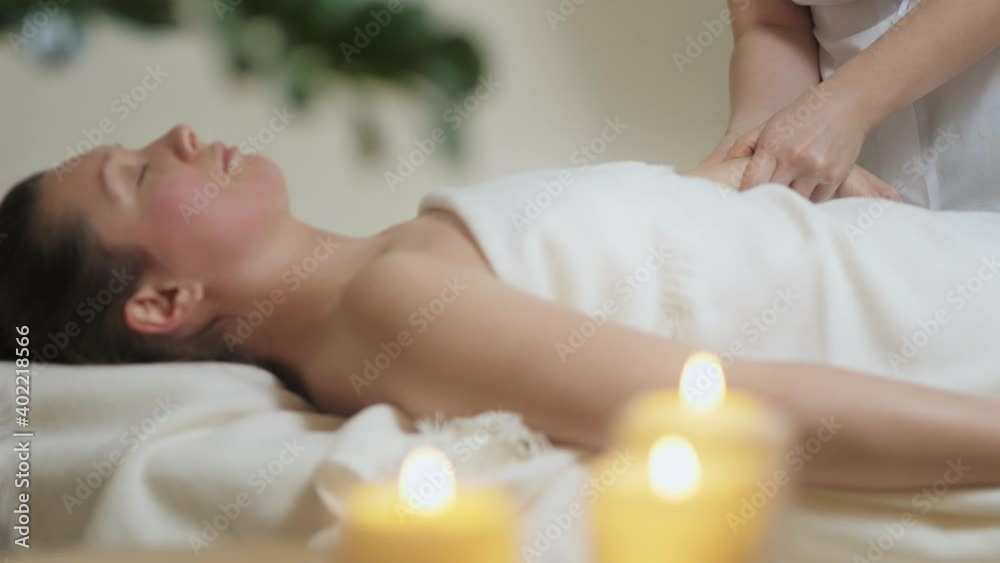 A pretty brunette woman gets a hand massage in the bright office of the spa salon. High quality 4k footage A pretty brunette woman gets a hand massage in the bright office of the spa salon. High quality 4k footage