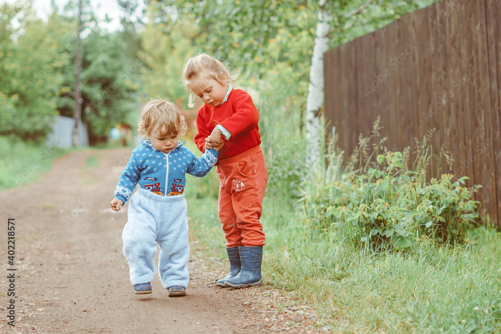 sister and brother walking down the street sister and brother walking down the street