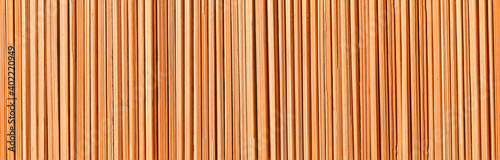 Fototapeta Naklejka Na Ścianę i Meble -  Wooden background. A texture consisting of vertical dry bamboo sticks of irregular round shape.