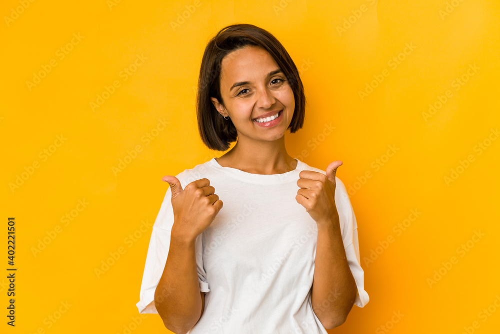 Young hispanic woman isolated on yellow raising both thumbs up, smiling and confident. Young hispanic woman isolated on yellow raising both thumbs up, smiling and confident.
