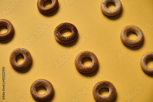 Top view of Sushki pattern on yellow surface. dish of Russian and Ukrainian cuisine, solid ring-shaped product made of dough, type of mutton products. One of the most common tea snacks among Slavs