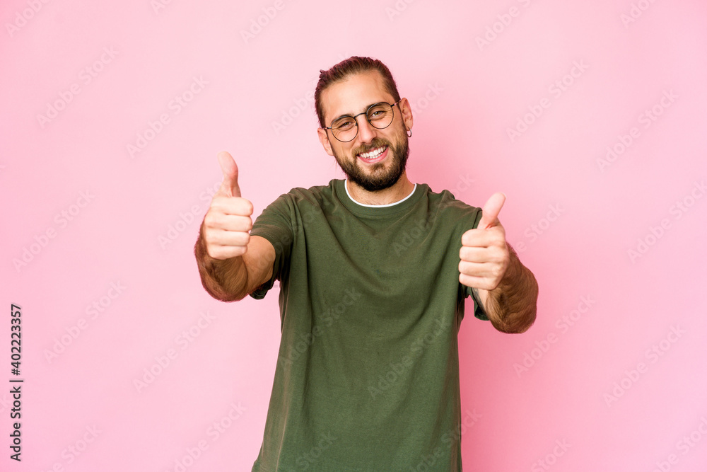 Young man with long hair look smiling and raising thumb up Young man with long hair look smiling and raising thumb up