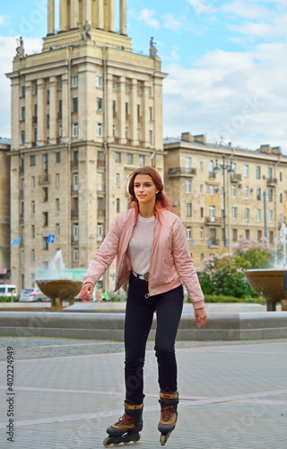 Girl riding on roller skates on the background of high-rise Stalin's building in St. Petersburg