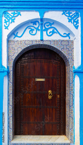 Decorated wall and door in medina of blue town Chefchaouen, Morocco. Translation: Post