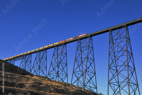 Lethbridge, Alberta, Canada -  December 21, 2020: Train going over large trellis train bridge in Alberta prairie in Lethbridge photo