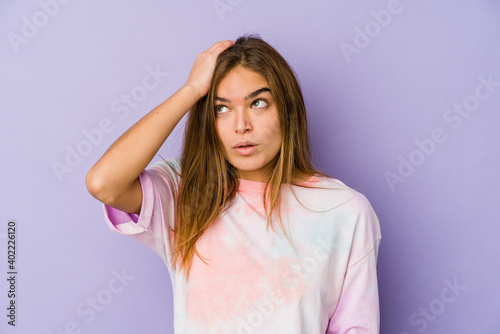 Young skinny caucasian girl teenager on purple background being shocked, she has remembered important meeting.