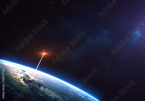 Rocket launch from the Earth planet through the clouds with a bright glow of the engine on the orbit and a bright blue nebula galaxy. Elements of this image furnished by NASA