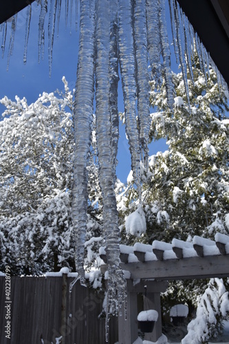 Closeup of icicle ripple formation from the roof of the house with water droplets during winter. Icicle ripple formation is due to the impurity of water.