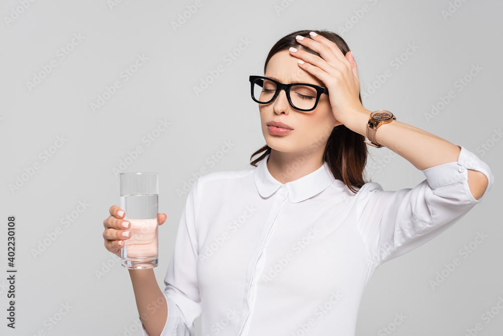 young pregnant businesswoman in glasses with glass of water isolated on grey young pregnant businesswoman in glasses with glass of water isolated on grey
