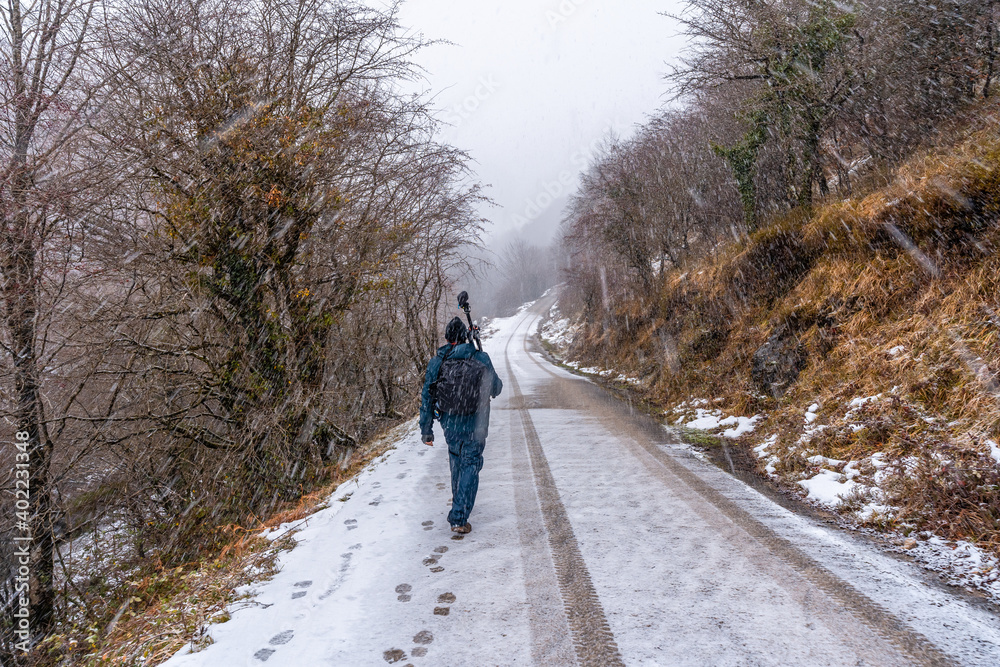 A young photographer walking in the aizkorri mountain of gipuzkoa. Snowy landscape by winter snows. Basque Country, Spain