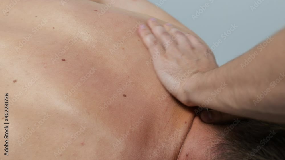Relaxation massage, male client getting back massage procedure of shoulders and neck Relaxation massage, male client getting back massage procedure of shoulders and neck