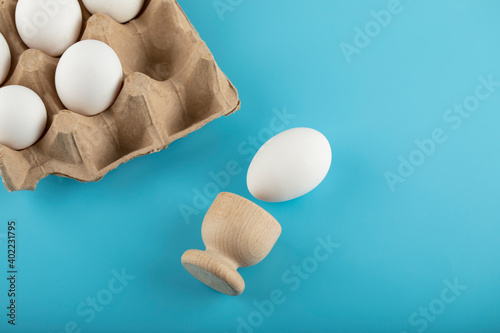 Fototapeta Naklejka Na Ścianę i Meble -  Container of fresh eggs on blue background