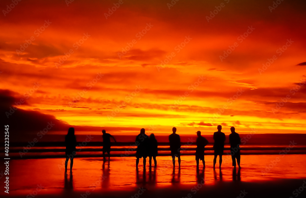 Fototapeta premium Beautiful sunset ocean sea beach orange sky people silhouette