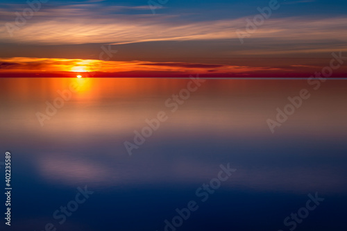 The abstract and minimal landscape of an orange and golden sunset over Ontario lake