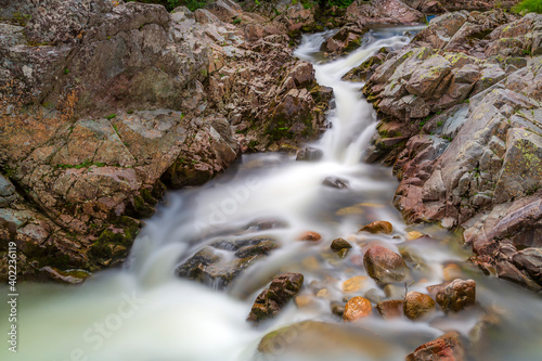 Long exposure of the clear rushing waters of Acadian forest flows between the crevasse of a Canadian landscape in Nova Scotia