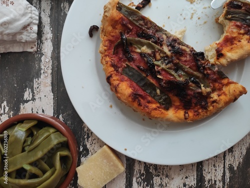 Homemade pizza with flatbeans on an old wood table
