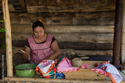 Hispanic woman in an apron preparing traditional Mexican tortillas in an outdoors kitchen