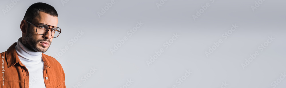 Stylish man in eyeglasses looking at camera on grey background, banner Stylish man in eyeglasses looking at camera on grey background, banner