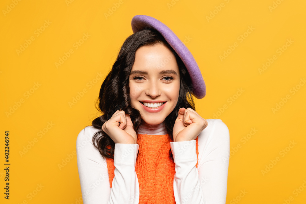 brunette woman with yes gesture wearing beret and looking at camera isolated on yellow brunette woman with yes gesture wearing beret and looking at camera isolated on yellow