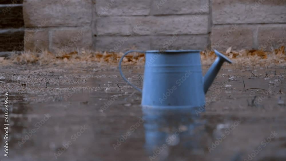 Slow-Motion watering can in the rain Slow-Motion watering can in the rain