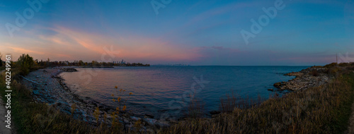 The city of Toronto is seen in the distance in this panoramic view across lake Ontario, taken from Colonel Samuel Smith Park in Toronto (Etobicoke), Ontario during a late evening sunset.