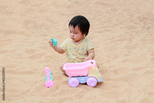 cute little baby girl play sand on sea beach