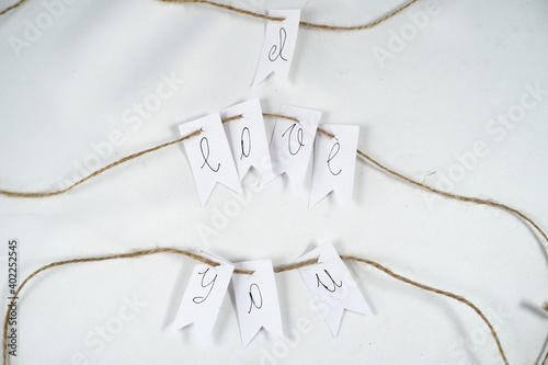 "I love you" paper and rope ornament for Valentine's day on horizontal white background