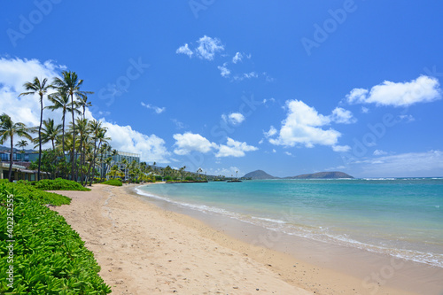 Palm trees on an empty sandy beach along the quiet and uncrowded Kahala Beach area in Honolulu on Oahu, Hawaii. photo