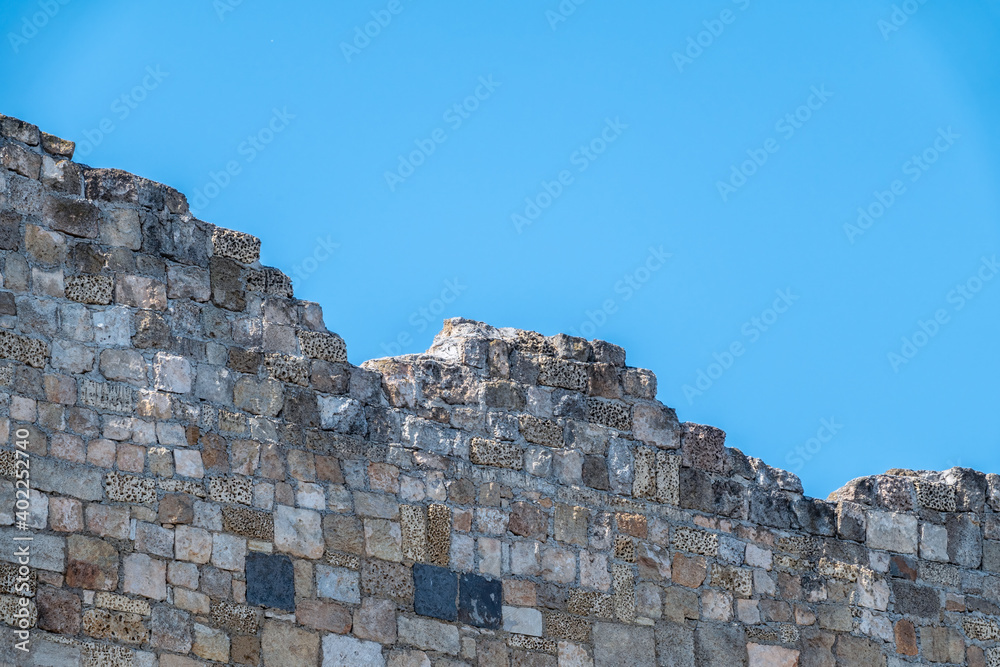 Ruins of the fortress wall against the blue sky