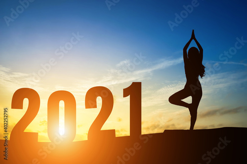 Happy New Year Numbers 2021, Silhouette woman practicing yoga early morning sunrise over the horizon background, Health and Happy new year concept.