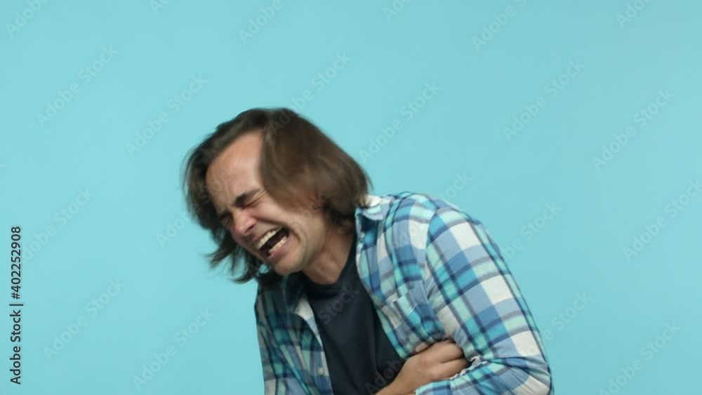 Lmfao. Slow motion of middle-aged guy chuckle, laughing out loud, having fun and watching comedy, standing over blue background Lmfao. Slow motion of middle-aged guy chuckle, laughing out loud, having fun and watching comedy, standing over blue background