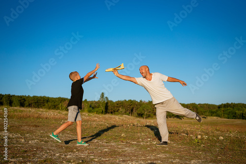 Dad and son play airplane in nature