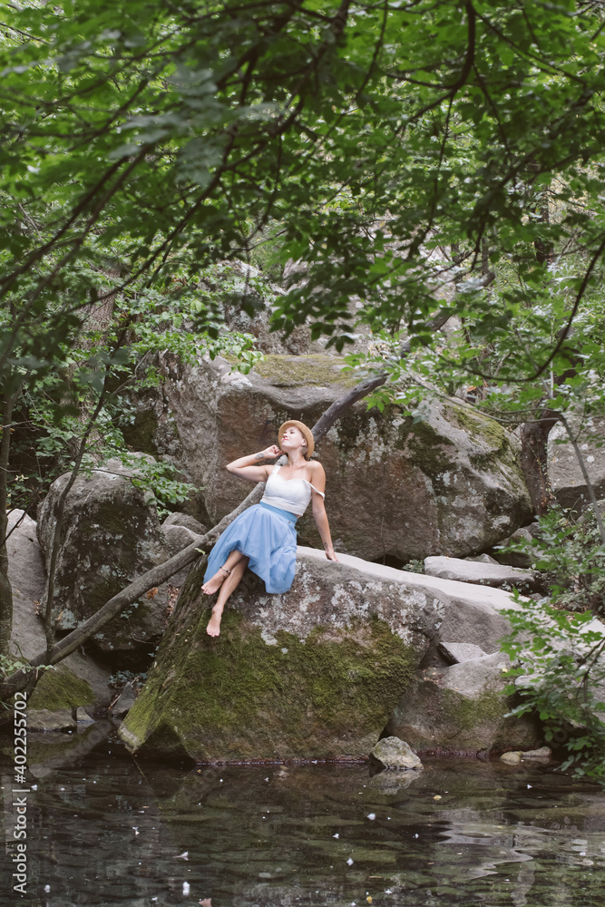A girl in a blue skirt is walking in a beautiful forest A girl in a blue skirt is walking in a beautiful forest