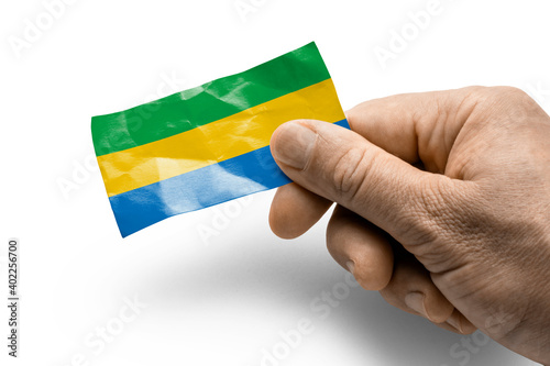 Hand holding a card with a national flag the Gabon