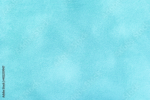 Light blue matte background of suede fabric, closeup. Velvet texture of textile.