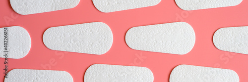 pure empty women's disposable daily menstrual sanitary pads or napkins pattern on pink background. banner