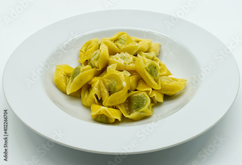 Tortelloni with ricotta, sage and Parmigiano Reggiano cheese, isolated on white background. Traditional italian pasta. 