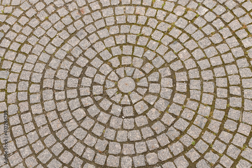 Old grey pavement of cobble stones in a circle pattern in an old medieval european town.