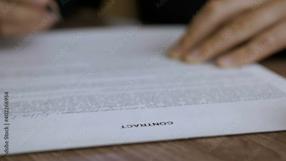  The man corrects and fills the document. Businessman signing business contract agreement, close up of male hand with pen writing signature.
