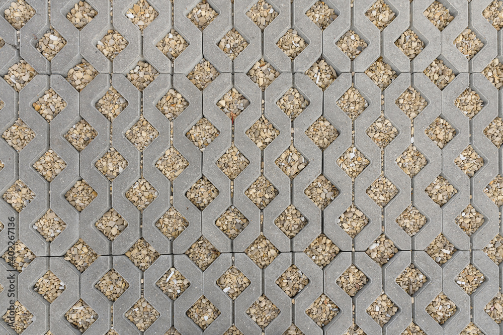 geometric concrete tile with holes. Covering for car parking. the holes are filled with small stones