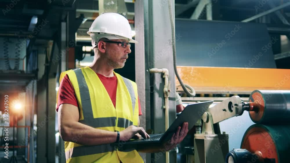 Factory worker is monitoring industrial equipment Factory worker is monitoring industrial equipment