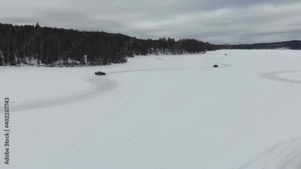 Cloudy day at frozen lake track with cars chasing on slippery circuit, aerial Cloudy day at frozen lake track with cars chasing on slippery circuit, aerial
