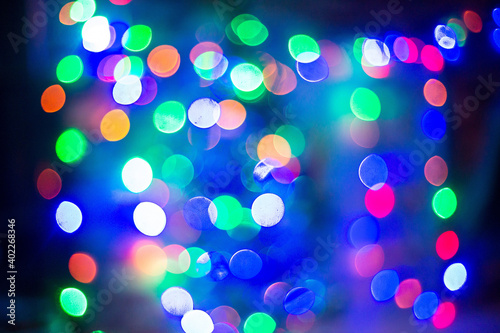 Colorful defocused bokeh lights in blur night background. cloud of multicolored particles in the air like sparkles on a dark background with depth of field. beautiful bokeh light effects with colored 