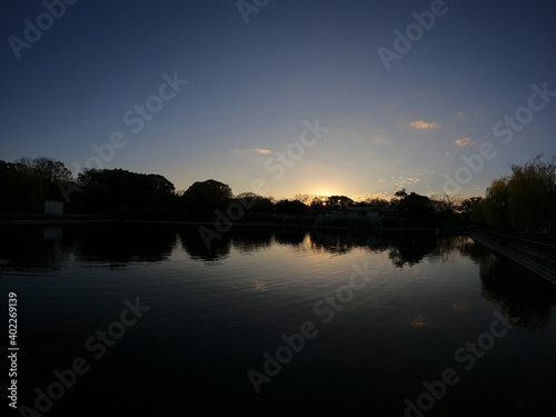 日本の有名な公園にある池に沈む鮮やかな夕日